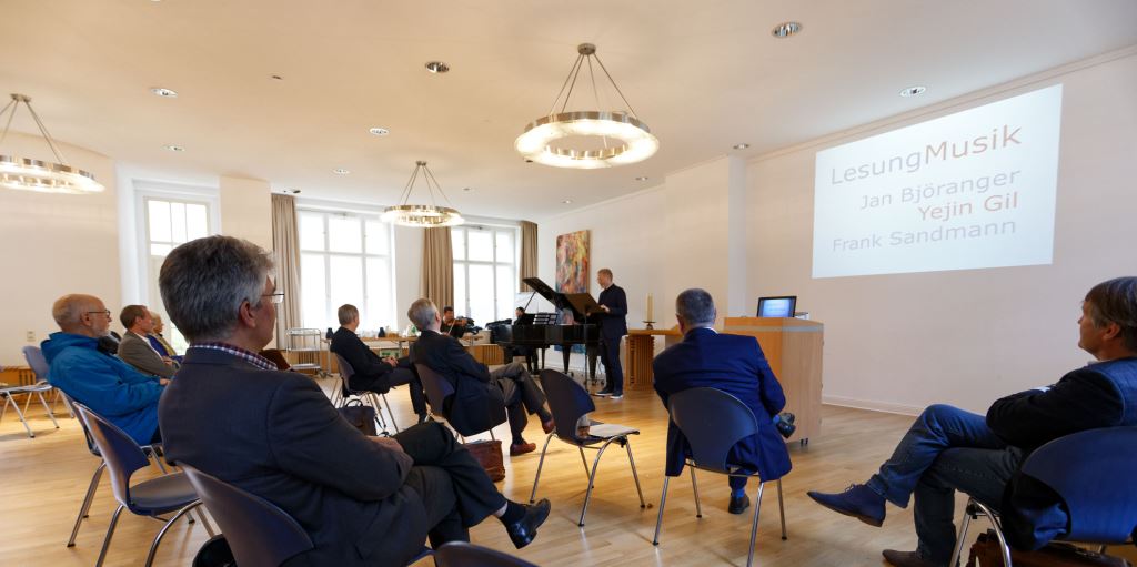 Foto: Blick übers Publikum aufs Podium des Fachtages 2021, Lesung und Musik