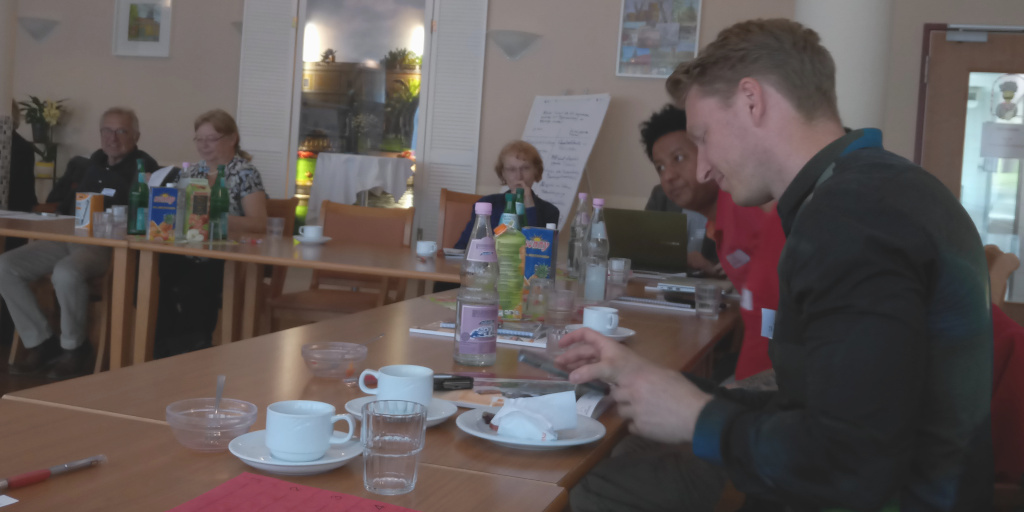 Foto: Teilnehmer sitzend am Konferenztisch