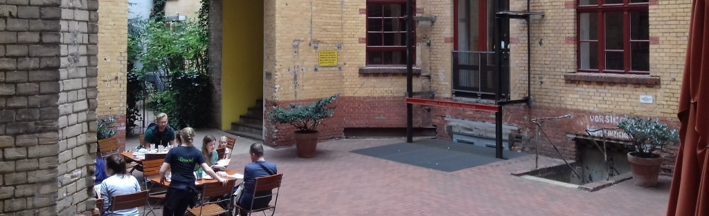 Foto: Berliner Gewerbehof, Sitzgruppe mit Gästen eines Cafés